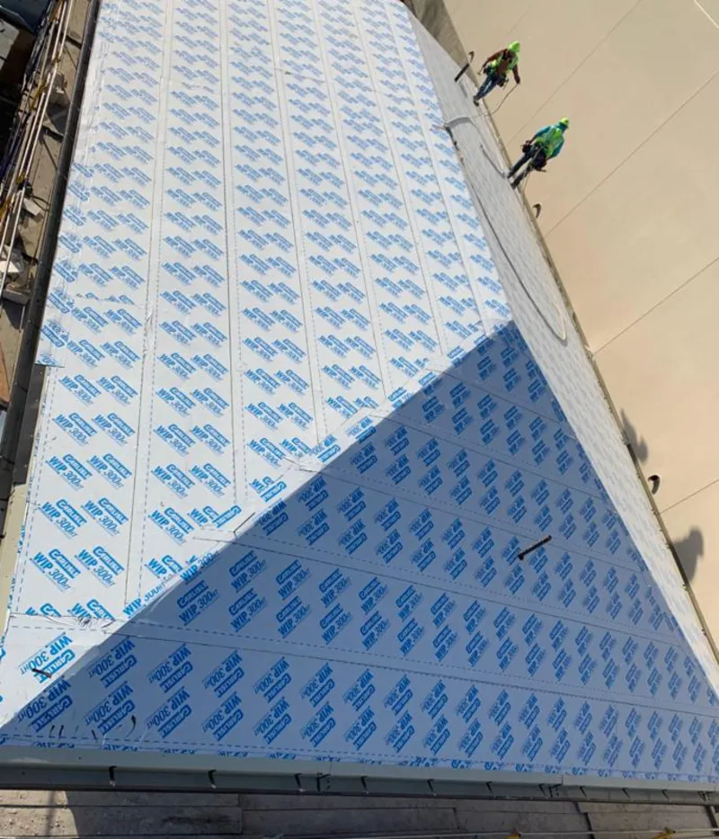 Professional roofers installing underlayment on a metal roof in Coeymans